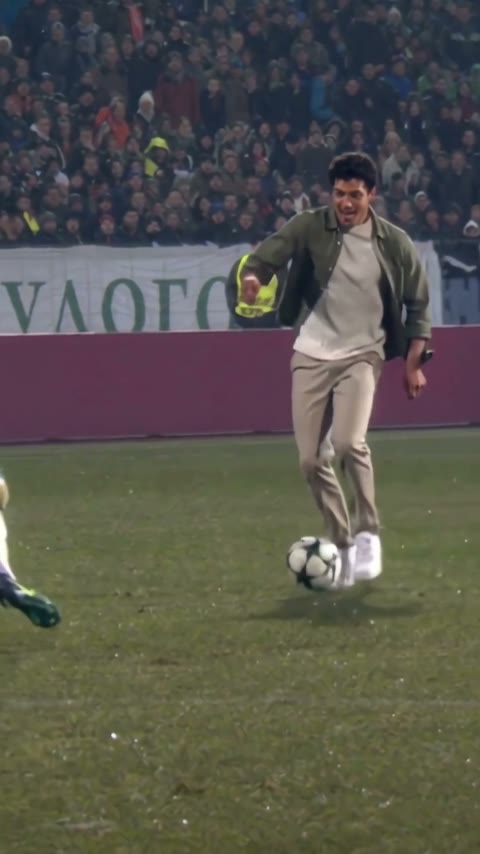 Our AI-generated player in a casual jacket running onto the football in a stadium
